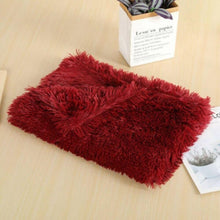 Load image into Gallery viewer, A soft wine red anxiety relieving blanket folded nicely on a wooden table with a little potted plant and some papers
